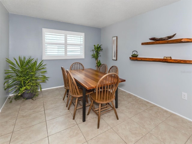 tiled dining room featuring a textured ceiling