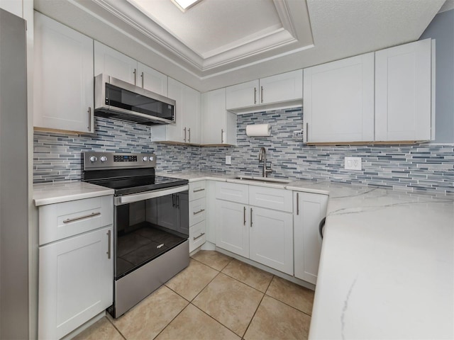 kitchen featuring backsplash, stainless steel appliances, white cabinets, and sink