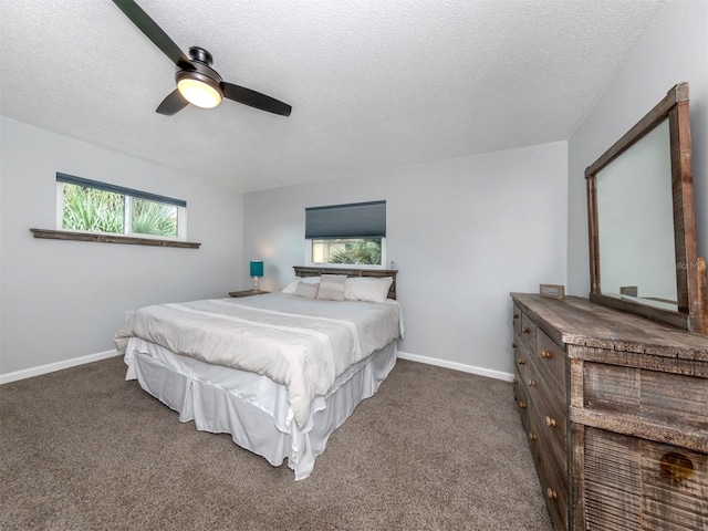 bedroom featuring ceiling fan, a textured ceiling, carpet, and multiple windows