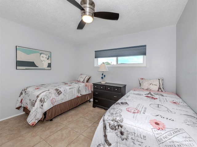 bedroom with ceiling fan, light tile patterned floors, and a textured ceiling