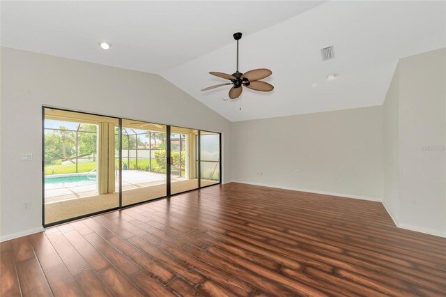 spare room with ceiling fan, wood finished floors, visible vents, baseboards, and vaulted ceiling