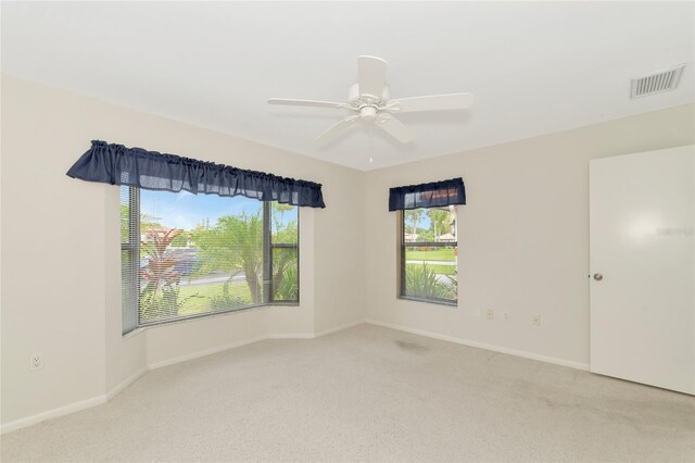 spare room with baseboards, visible vents, ceiling fan, and carpet flooring