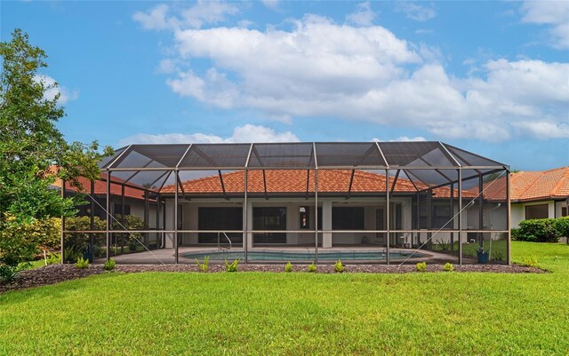 back of house featuring a patio area, an outdoor pool, glass enclosure, and a yard