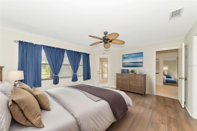 bedroom with visible vents, ceiling fan, and wood finished floors