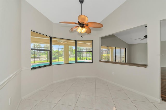 spare room with a ceiling fan, lofted ceiling, baseboards, and tile patterned floors