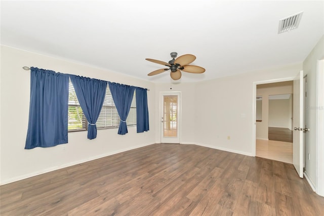 empty room with visible vents, baseboards, ceiling fan, and wood finished floors