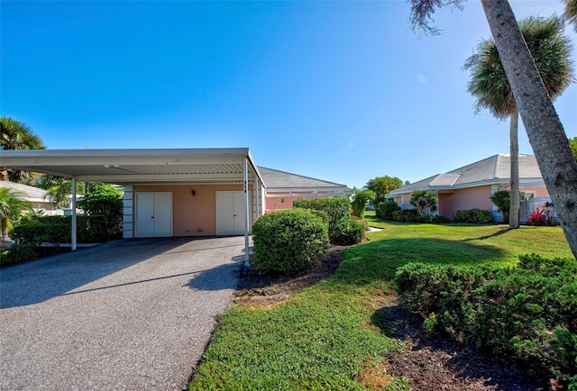 garage featuring a lawn and a carport