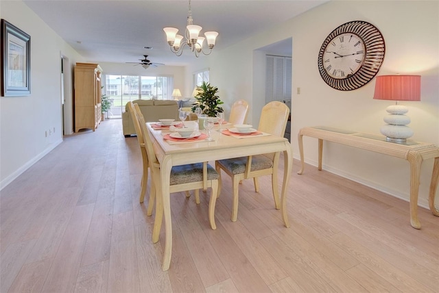 dining area featuring light hardwood / wood-style flooring and ceiling fan with notable chandelier