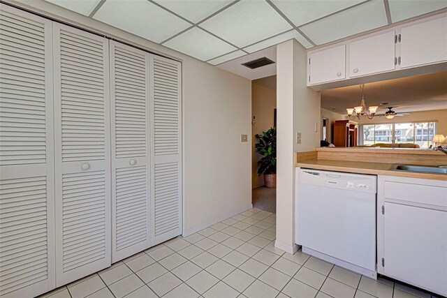 kitchen with white cabinets, white dishwasher, hanging light fixtures, light tile patterned floors, and sink