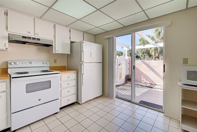 kitchen with a drop ceiling, white appliances, white cabinetry, and light tile patterned flooring