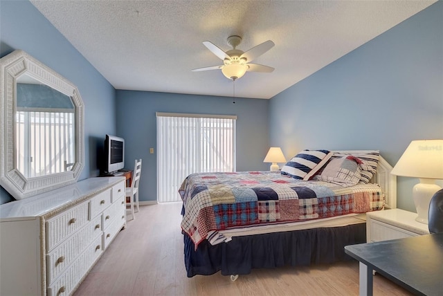 bedroom featuring ceiling fan, a textured ceiling, light wood-type flooring, and multiple windows