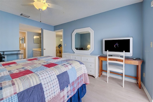 bedroom with ceiling fan, a textured ceiling, and connected bathroom