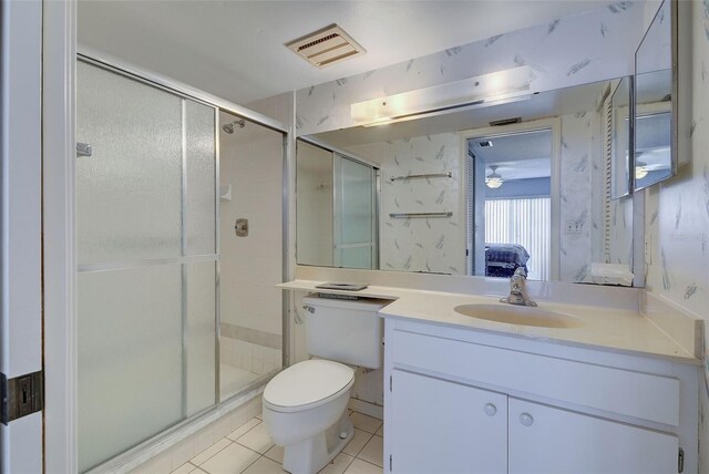 bathroom with tile patterned floors, walk in shower, vanity, and toilet