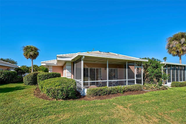 back of property featuring a lawn and a sunroom