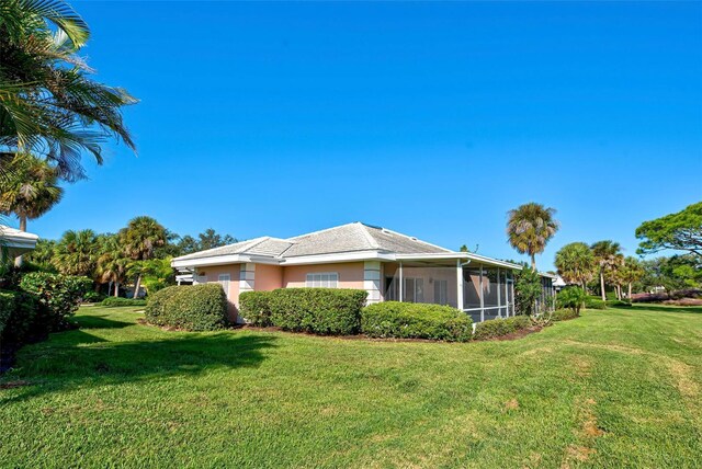 view of side of property featuring a yard and a sunroom