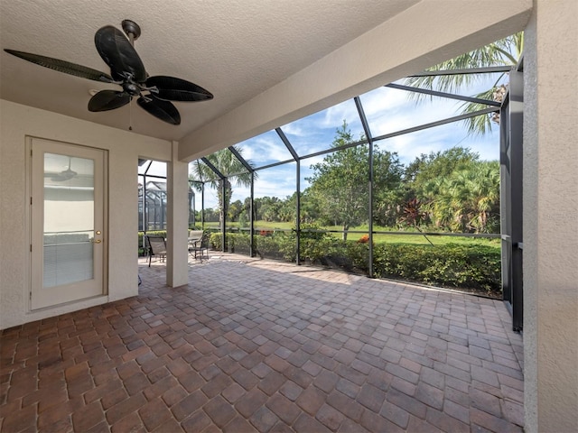 unfurnished sunroom featuring ceiling fan