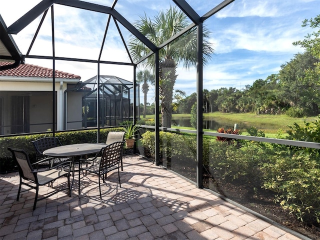 view of patio / terrace with a water view and glass enclosure