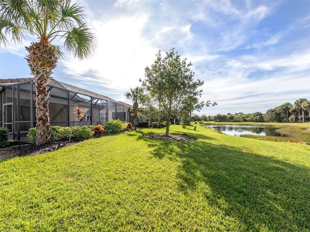 view of yard featuring glass enclosure and a water view