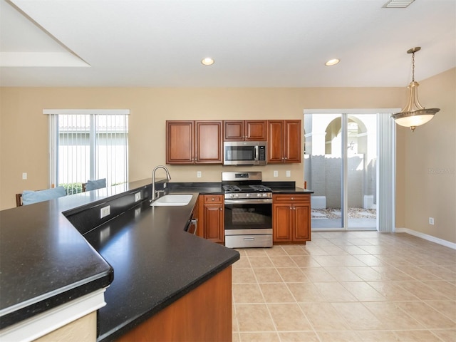 kitchen with kitchen peninsula, sink, light tile patterned flooring, hanging light fixtures, and stainless steel appliances