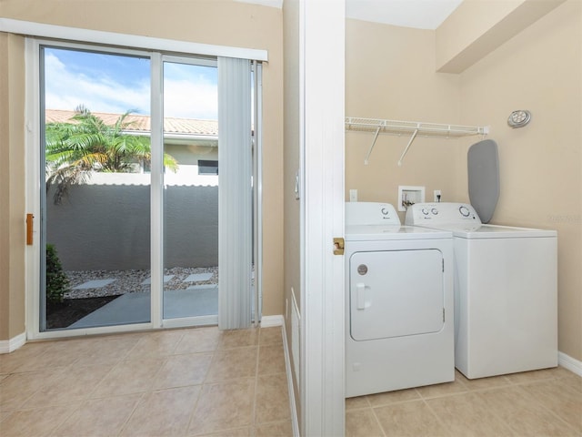 laundry area with light tile patterned floors and washing machine and dryer