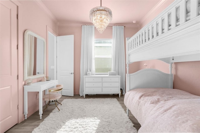 bedroom with hardwood / wood-style flooring, ornamental molding, and a chandelier