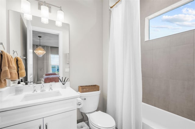 full bathroom featuring shower / bath combo with shower curtain, vanity, a chandelier, and toilet