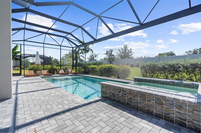 view of pool featuring an in ground hot tub, glass enclosure, and a patio area