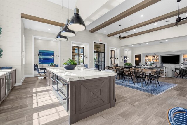 8209 Redonda Loop, Lakewood Ranch, FL 34202 - kitchen with beamed ceiling, light wood-type flooring, a ceiling fan, and open floor plan