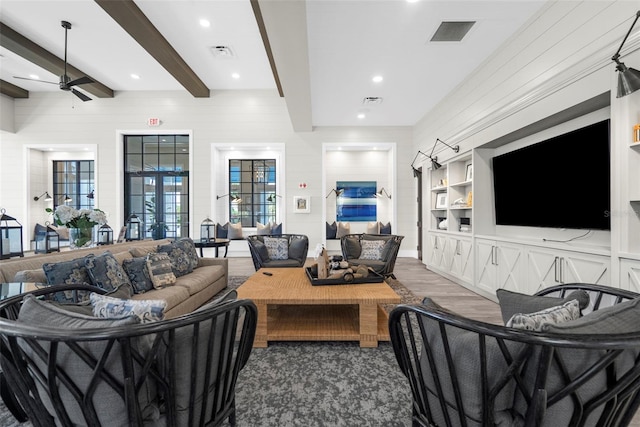 living room with french doors, ceiling fan, wooden walls, dark wood-type flooring, and beam ceiling