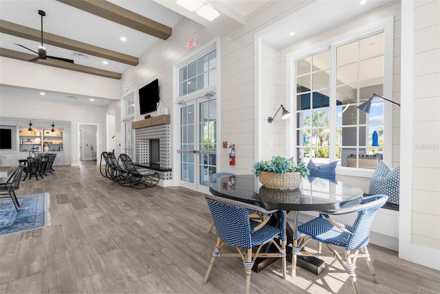 dining room with beam ceiling, ceiling fan, plenty of natural light, and hardwood / wood-style floors