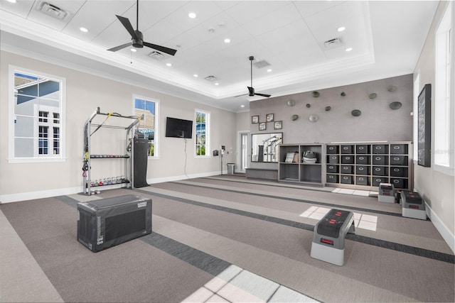 gym with carpet flooring, ceiling fan, a healthy amount of sunlight, and a tray ceiling