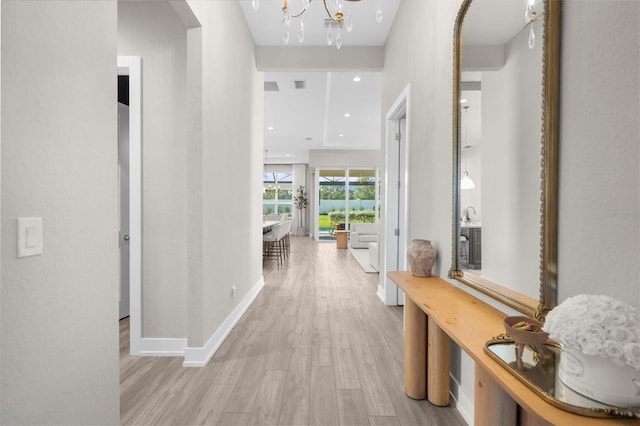 hall featuring a chandelier and light wood-type flooring