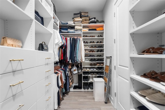 walk in closet with light hardwood / wood-style flooring