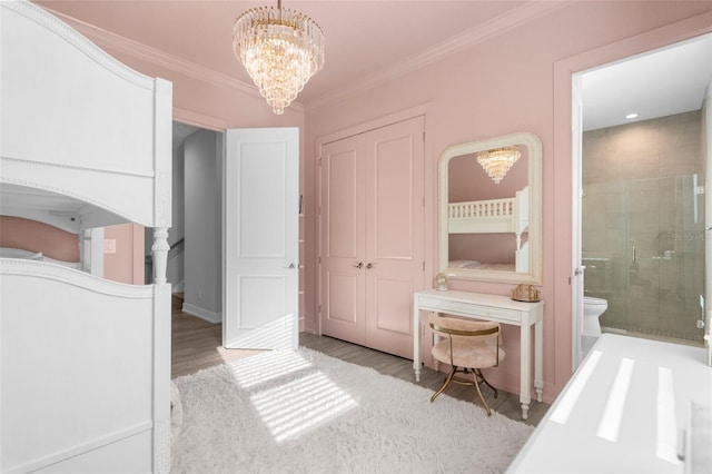 bedroom with ensuite bathroom, light wood-type flooring, ornamental molding, and an inviting chandelier