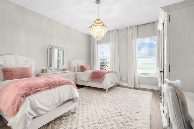 bedroom with wood-type flooring and a notable chandelier