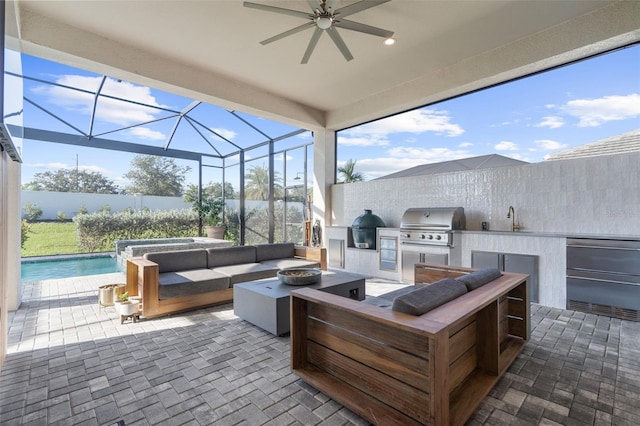 view of patio featuring glass enclosure, area for grilling, and sink