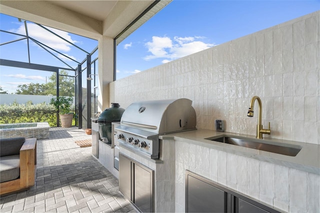 view of patio / terrace with a lanai, area for grilling, sink, and grilling area