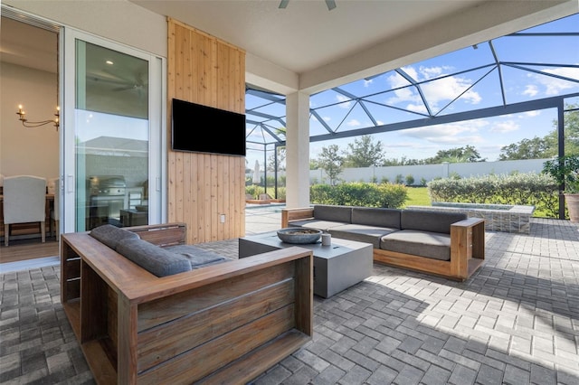 view of patio / terrace featuring glass enclosure and an outdoor living space with a fire pit