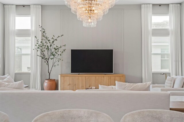 8209 Redonda Loop, Lakewood Ranch, FL 34202 - living room featuring an inviting chandelier and plenty of natural light