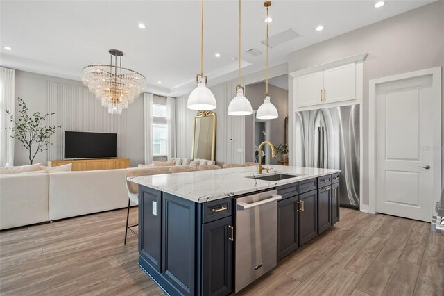 8209 Redonda Loop, Lakewood Ranch, FL 34202 - kitchen featuring light wood finished floors, a sink, stainless steel appliances, and open floor plan