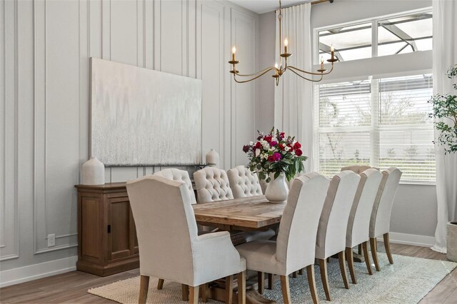 8209 Redonda Loop, Lakewood Ranch, FL 34202 - dining area with baseboards, light wood-style floors, and a notable chandelier