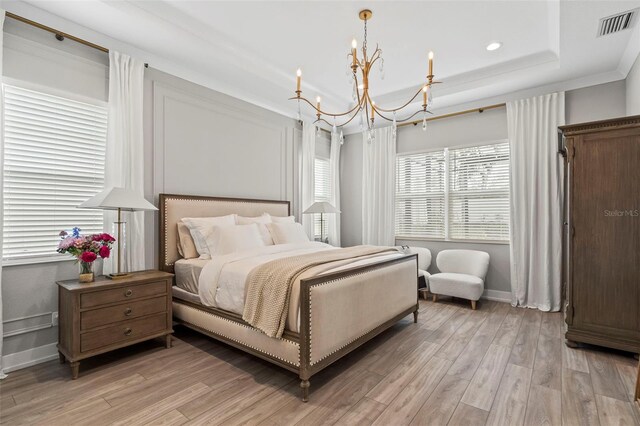 8209 Redonda Loop, Lakewood Ranch, FL 34202 - bedroom featuring a notable chandelier, a raised ceiling, light wood-style flooring, baseboards, and visible vents