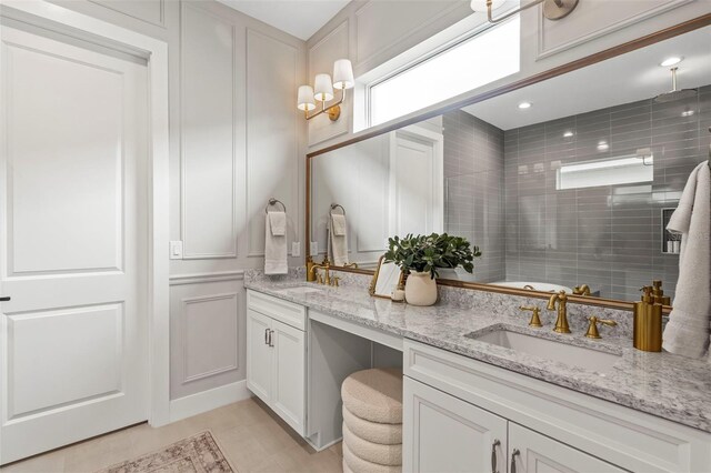 8209 Redonda Loop, Lakewood Ranch, FL 34202 - full bathroom with double vanity, a decorative wall, a sink, and tiled shower