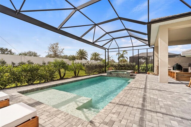 8209 Redonda Loop, Lakewood Ranch, FL 34202 - view of pool featuring a lanai, a fenced backyard, exterior kitchen, a pool with connected hot tub, and a patio area