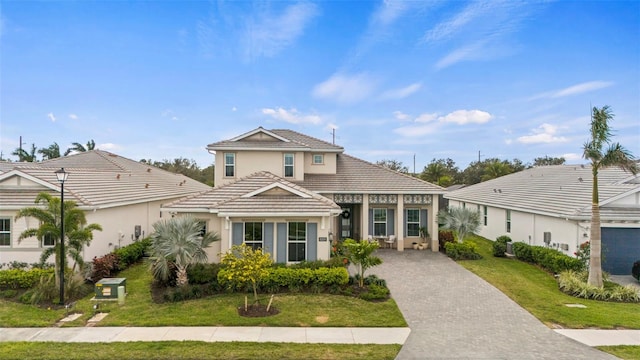 8209 Redonda Loop, Lakewood Ranch, FL 34202 - view of front of house with a front lawn, driveway, stucco siding, and a tiled roof