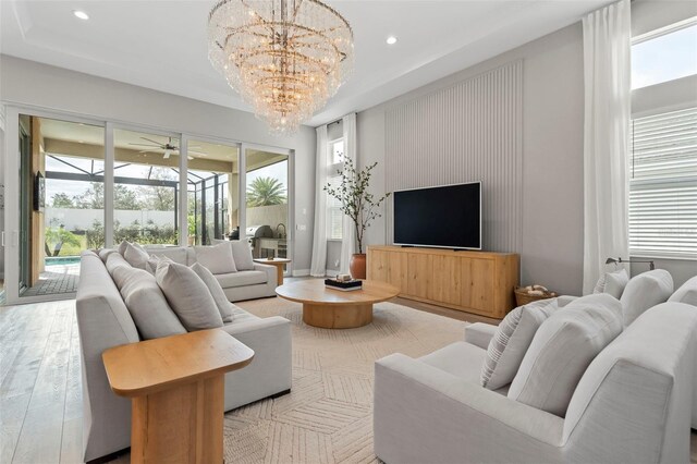 8209 Redonda Loop, Lakewood Ranch, FL 34202 - living area with ceiling fan with notable chandelier, wood finished floors, a sunroom, and recessed lighting