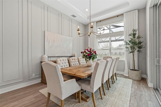 8209 Redonda Loop, Lakewood Ranch, FL 34202 - dining area with a raised ceiling, a notable chandelier, light wood-style flooring, and visible vents