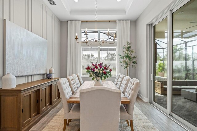8209 Redonda Loop, Lakewood Ranch, FL 34202 - dining area with visible vents, a chandelier, light wood finished floors, baseboards, and a raised ceiling