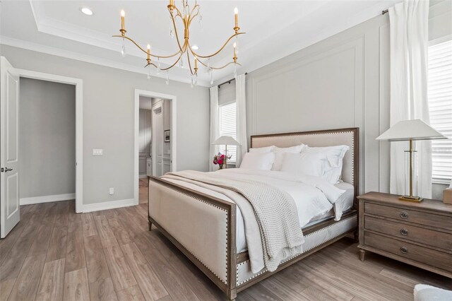 8209 Redonda Loop, Lakewood Ranch, FL 34202 - bedroom with a tray ceiling, a notable chandelier, wood finished floors, baseboards, and ornamental molding