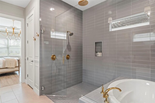 8209 Redonda Loop, Lakewood Ranch, FL 34202 - ensuite bathroom with a bath, connected bathroom, tile patterned floors, a stall shower, and an inviting chandelier